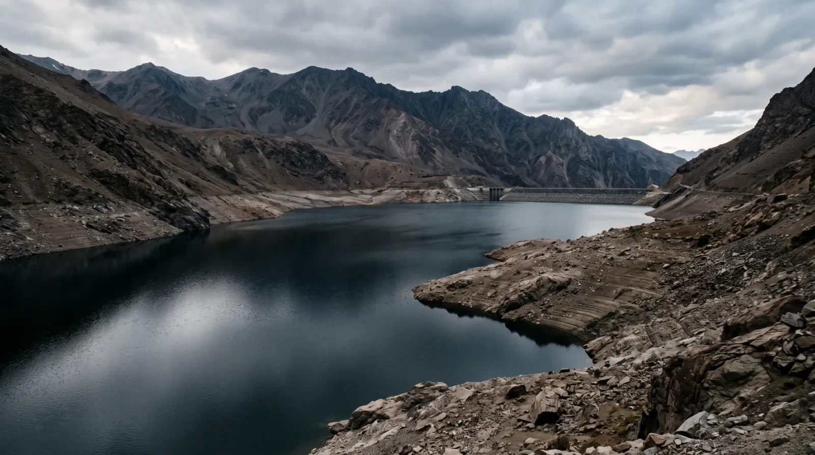 A mountain reservoir in late afternoon, dark still water