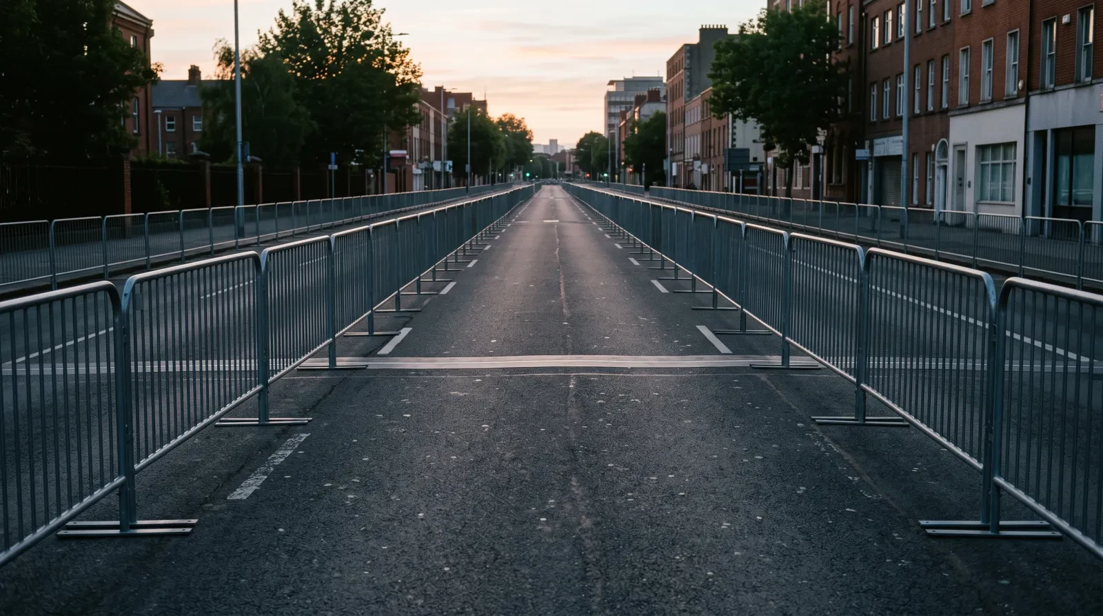 An empty finishing straight lined with plain barriers at dawn