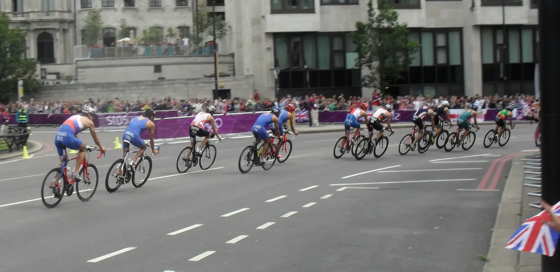 A group of elite triathletes riding through a city street