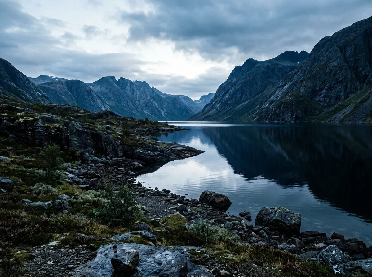 A cold lake with dark still water and a rocky shore